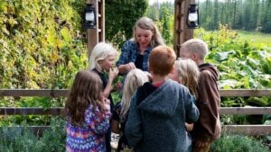 A woman handing out elderberry gummies to her children.