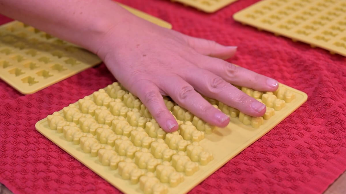 Silicone gummy bear molds turned upside down on a red towel.