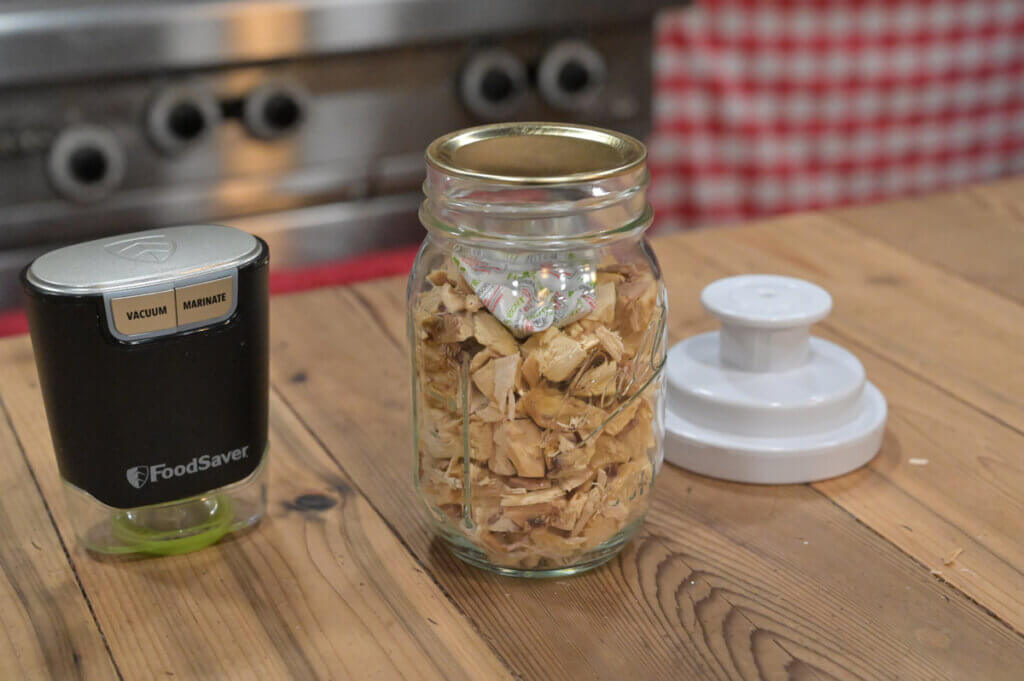 Freeze dried chicken in a glass jar with vacuum sealing tool.
