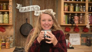 A woman holding a mug filled with cold and flu tea.