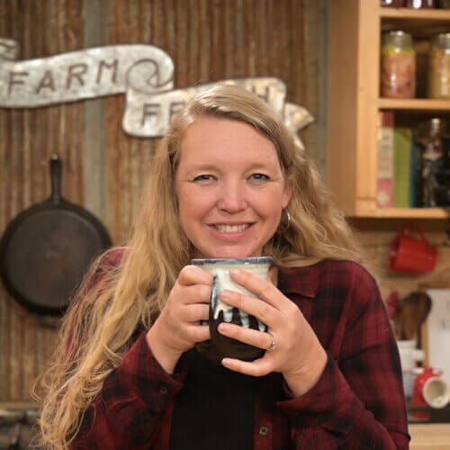 A woman holding a mug filled with cold and flu tea.