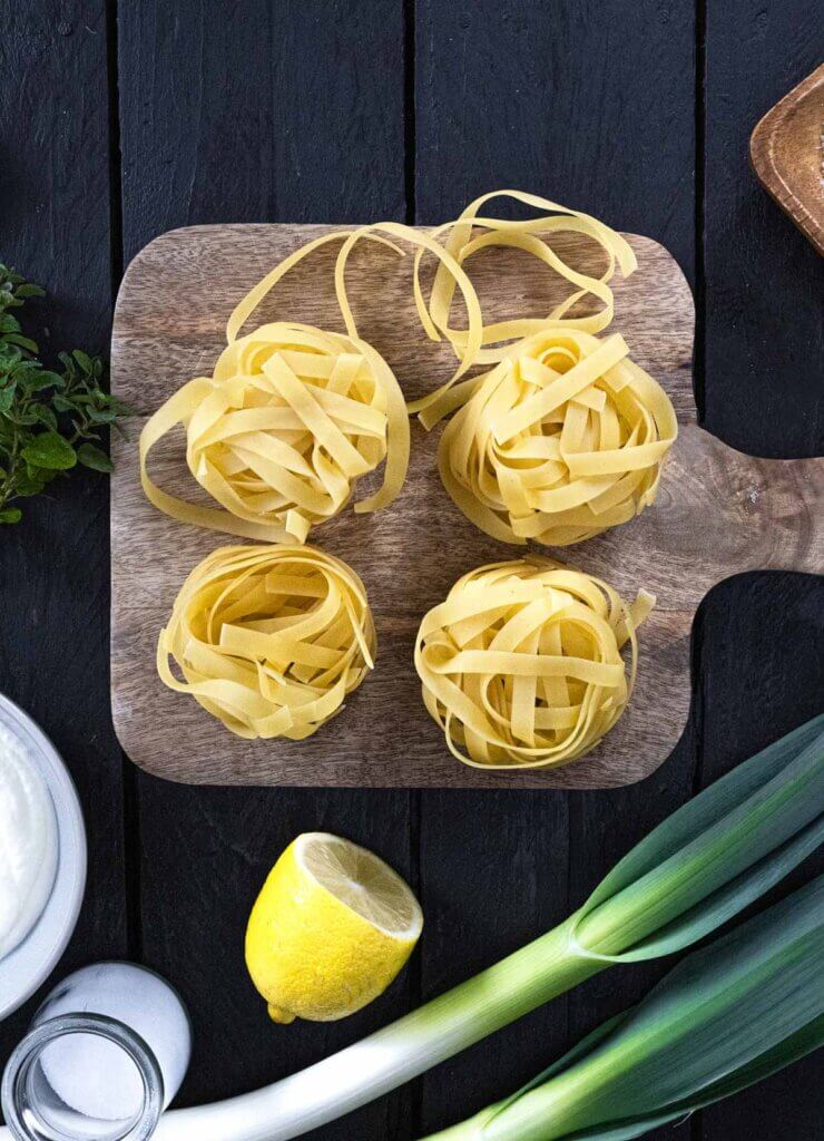 Dried pasta nests on a cutting board.