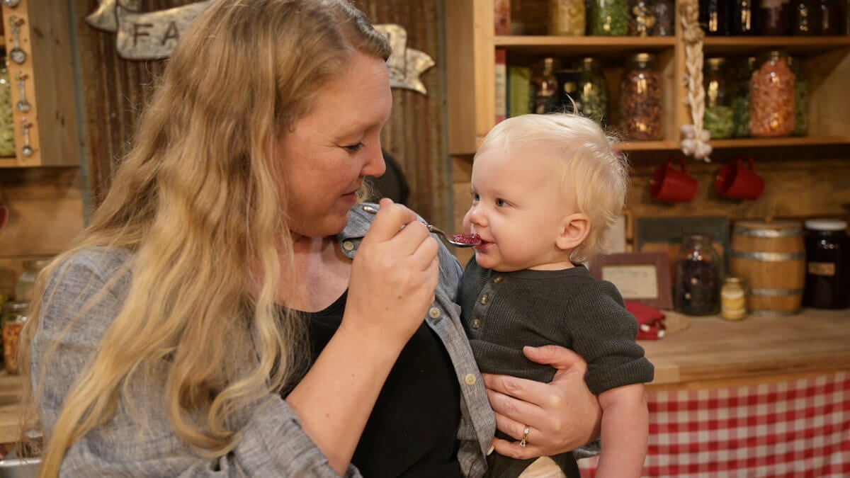 A mother feeding her baby homemade baby food.
