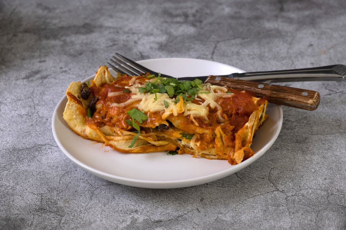 Black bean enchiladas served on a white plate.