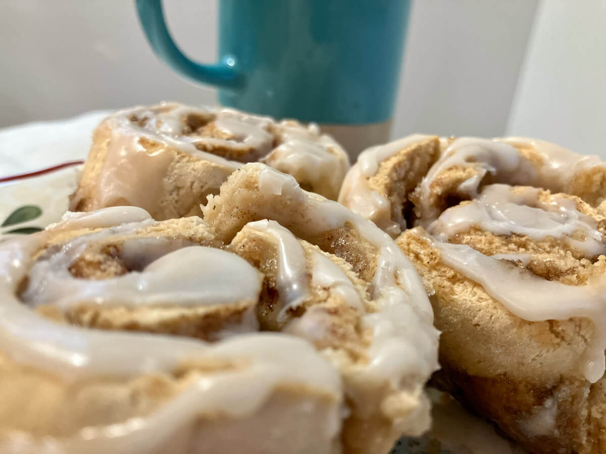 Gluten free cinnamon rolls, frosted on a plate.