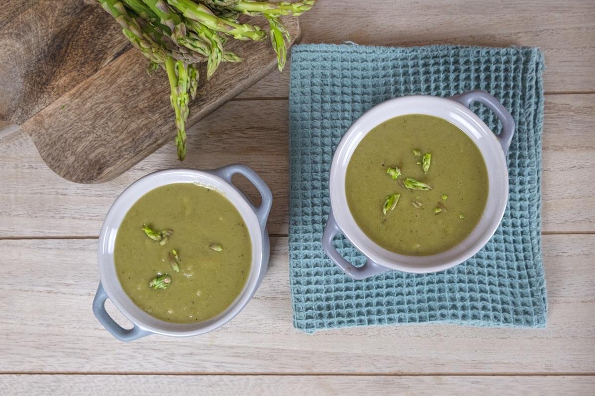 Overhead shot of creamy asparagus soup in a bowl.