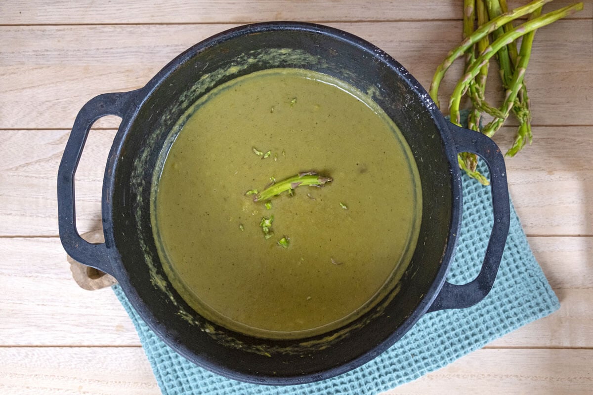 Overhead shot of creamy asparagus soup in a pot.