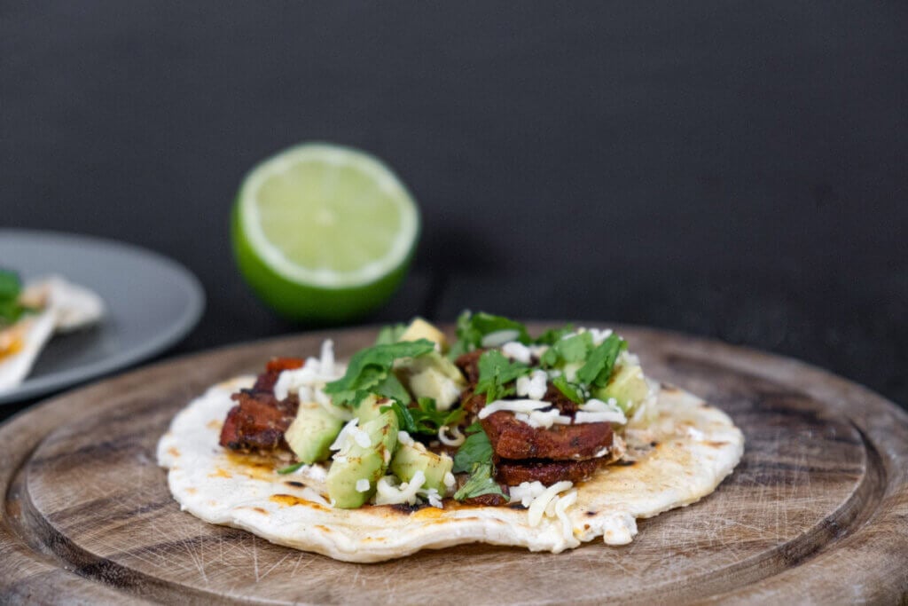 Beef tongue taco on a wooden platter.
