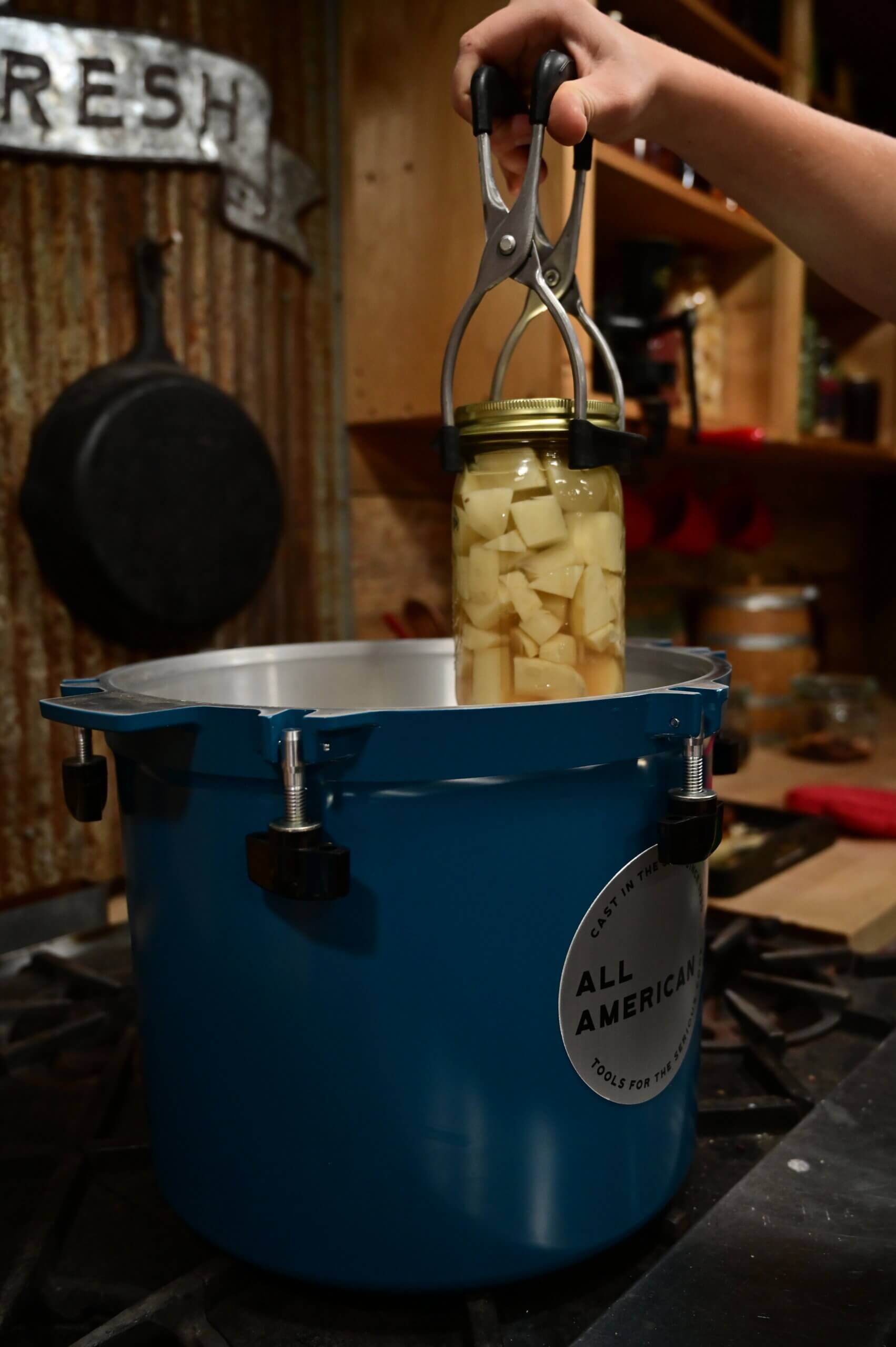 A jar of potatoes going into a pressure canner for canning.