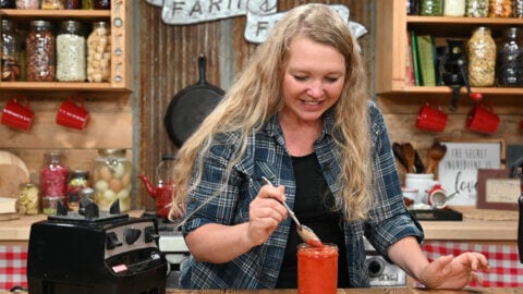 A woman tasting homemade fermented sriracha sauce.
