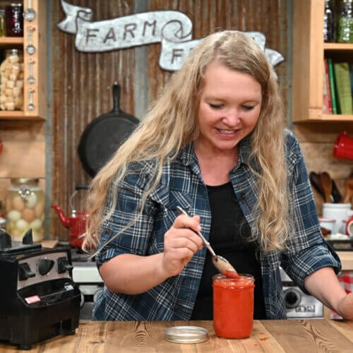 A woman tasting homemade fermented sriracha sauce.