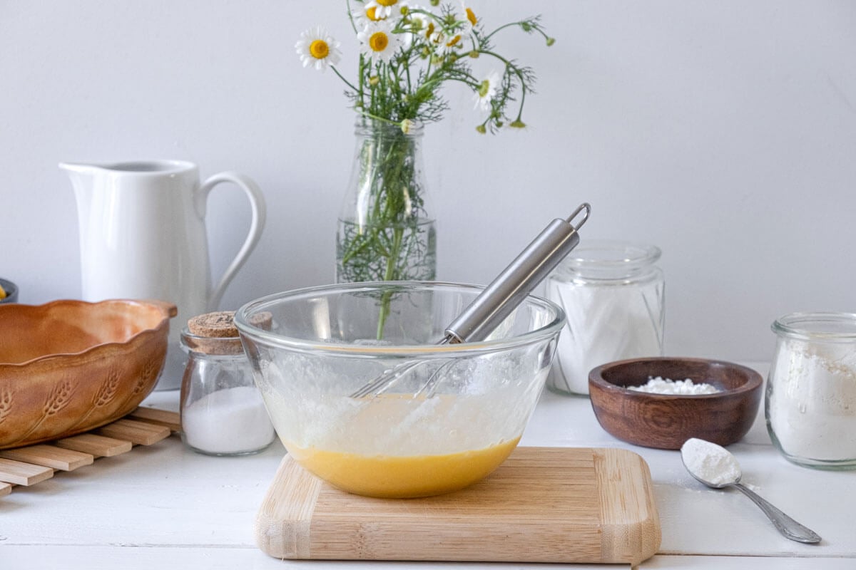 Corn pudding wet ingredients in a glass bowl.