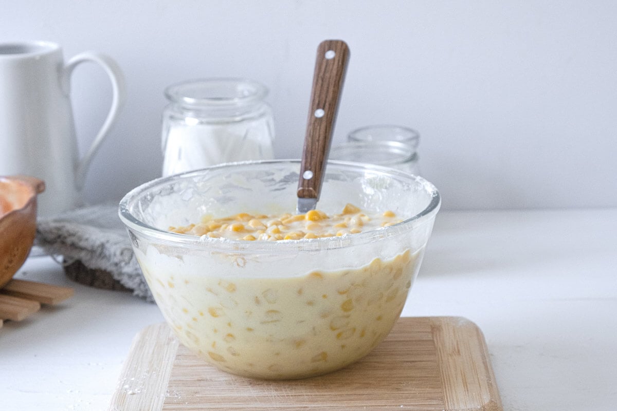 Corn pudding ingredients in a glass mixing bowl.