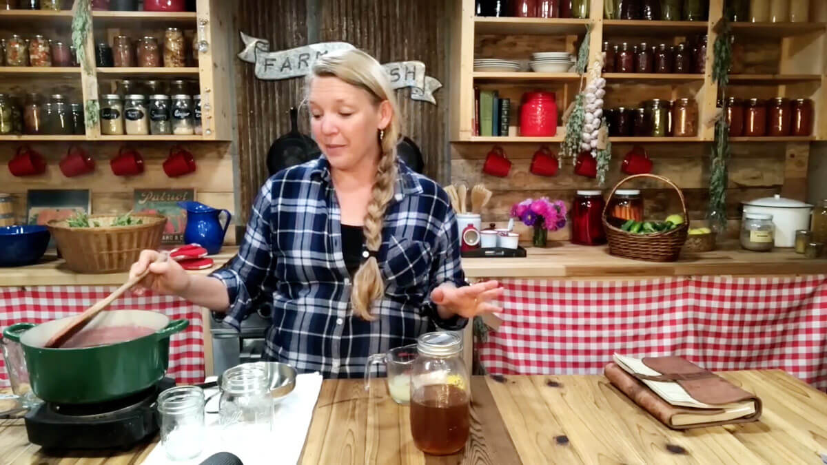 A woman stirring a pot of homemade elderberry syrup.