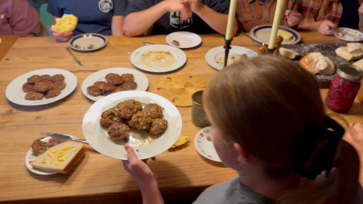 A family sitting around a table trying various pork sausage recipes.