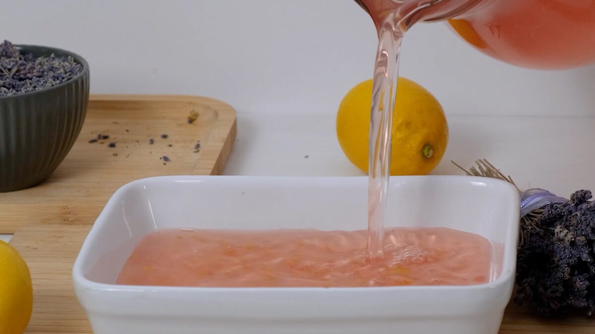 Lemon simple syrup being poured into a pan to freeze for lemon sorbet.