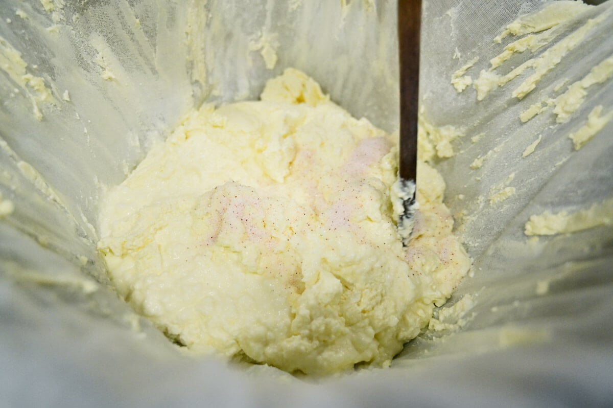 Salt being added to yogurt cheese.