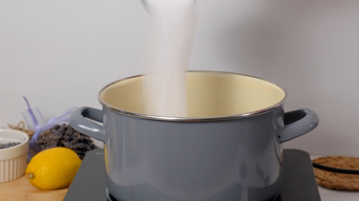 Sugar being added to a pot to make simple syrup.