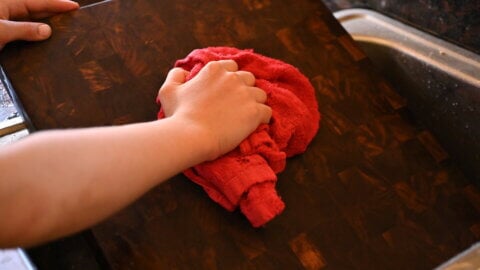 Hand drying a cutting board.