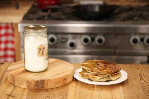 A stack of pancakes and a jar of pancake mix.