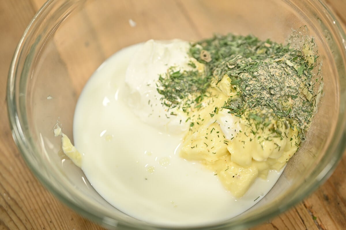 Ingredients for buttermilk ranch dressing in a glass bowl.