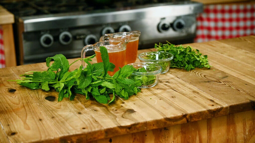 Honey and fresh herbs on a counter.
