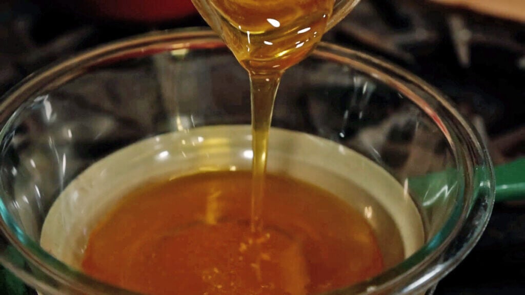 Honey being poured into a double boiler.
