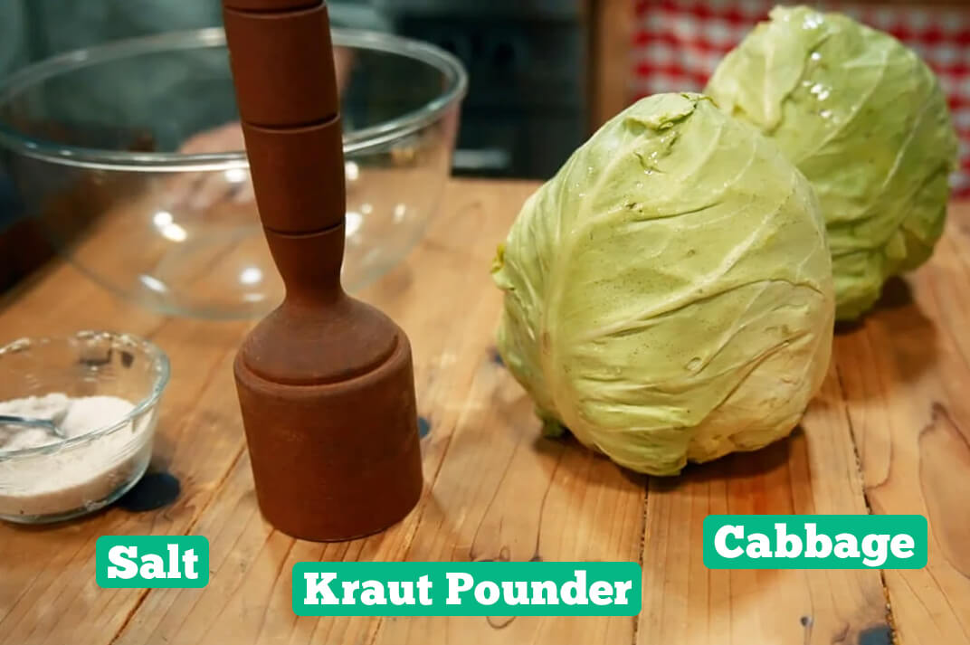 Sauerkraut ingredients and supplies: salt, cabbage, kraut pounder, and a bowl.