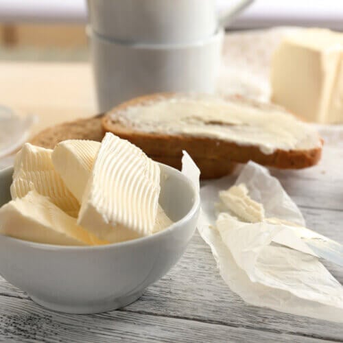 Slices of butter arranged in a white dish.