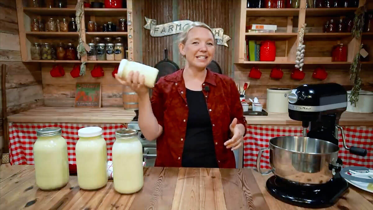 A woman shaking a jar of cream to make butter.