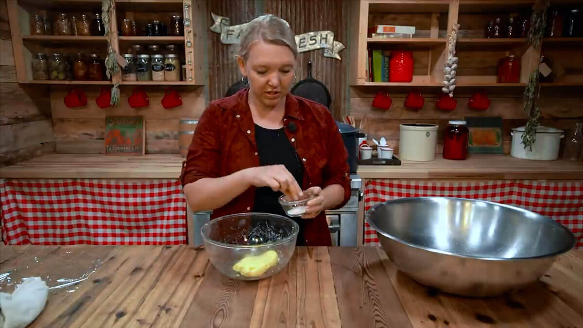 A woman sprinkling salt onto freshly churned butter.