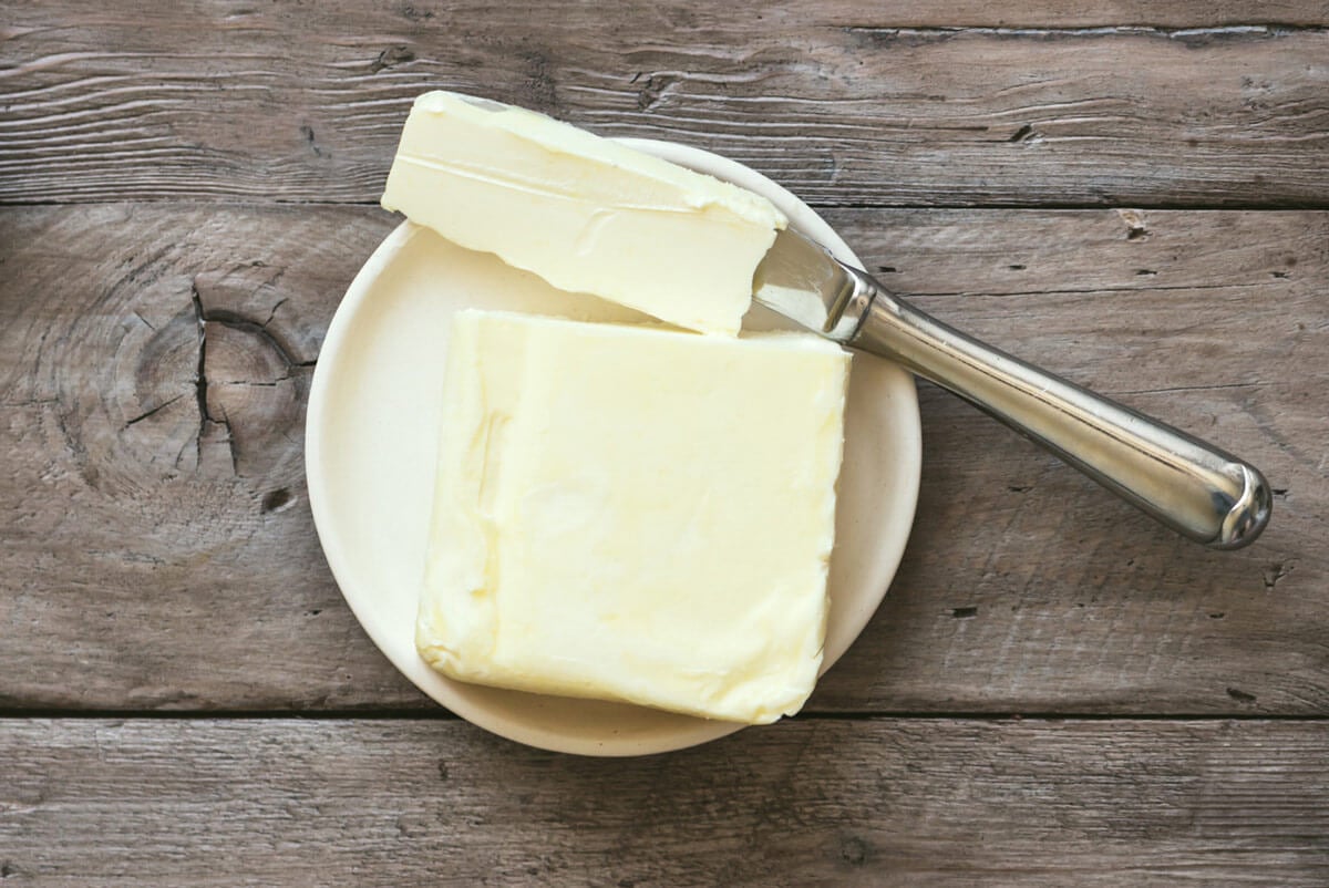 Butter in a dish with a knife full of butter.