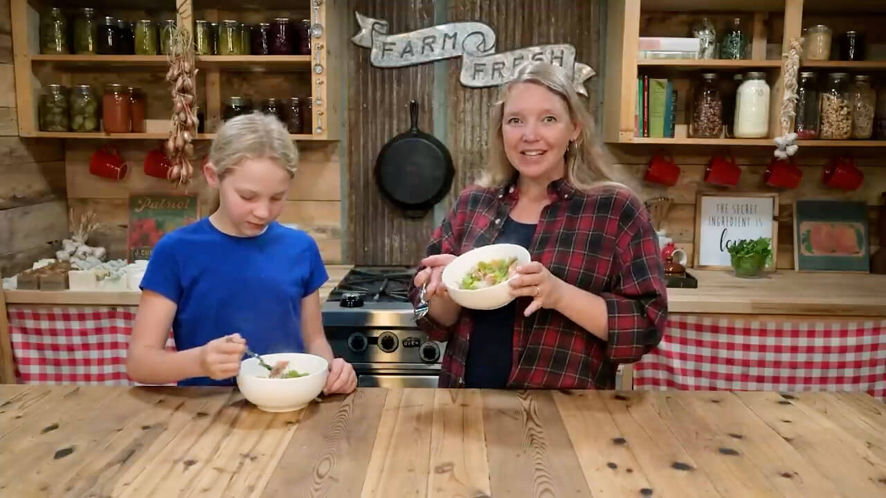 A woman and girl getting ready to eat mixed vegetable stir fry.