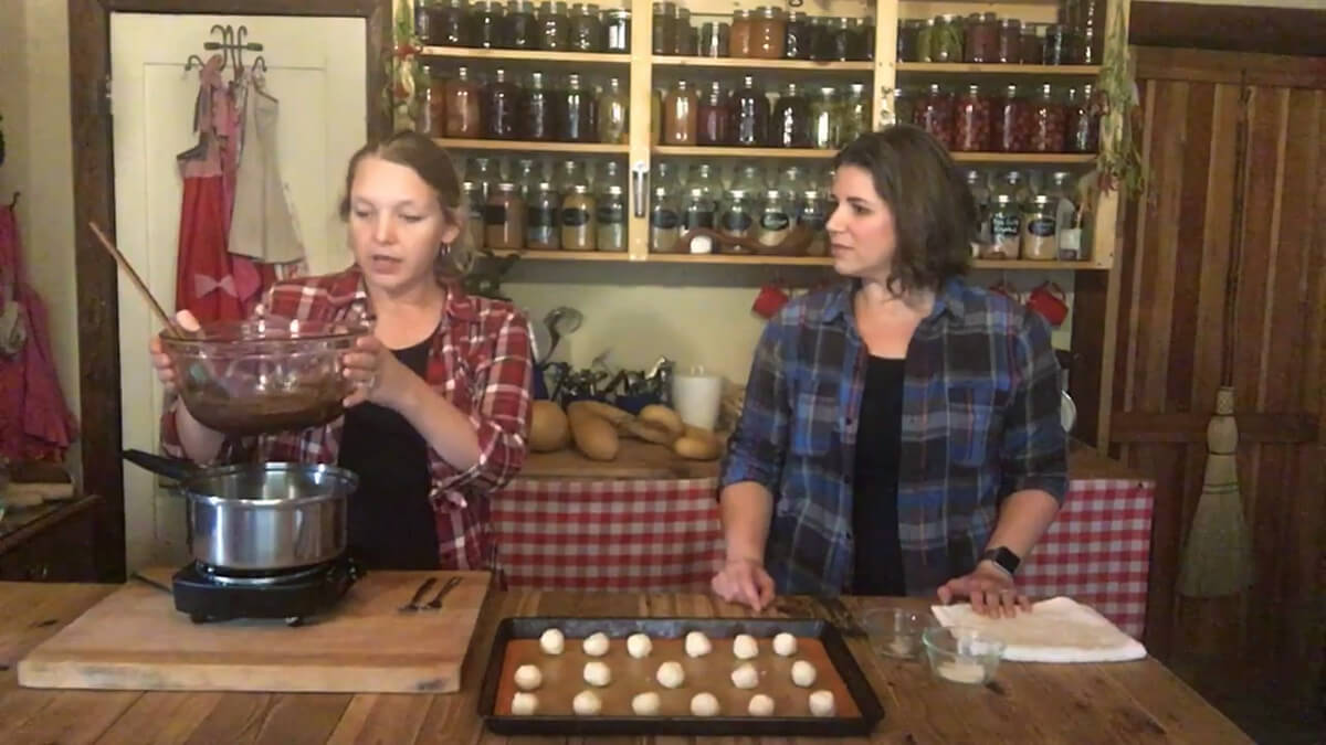 A woman melting chocolate using a double boiler.