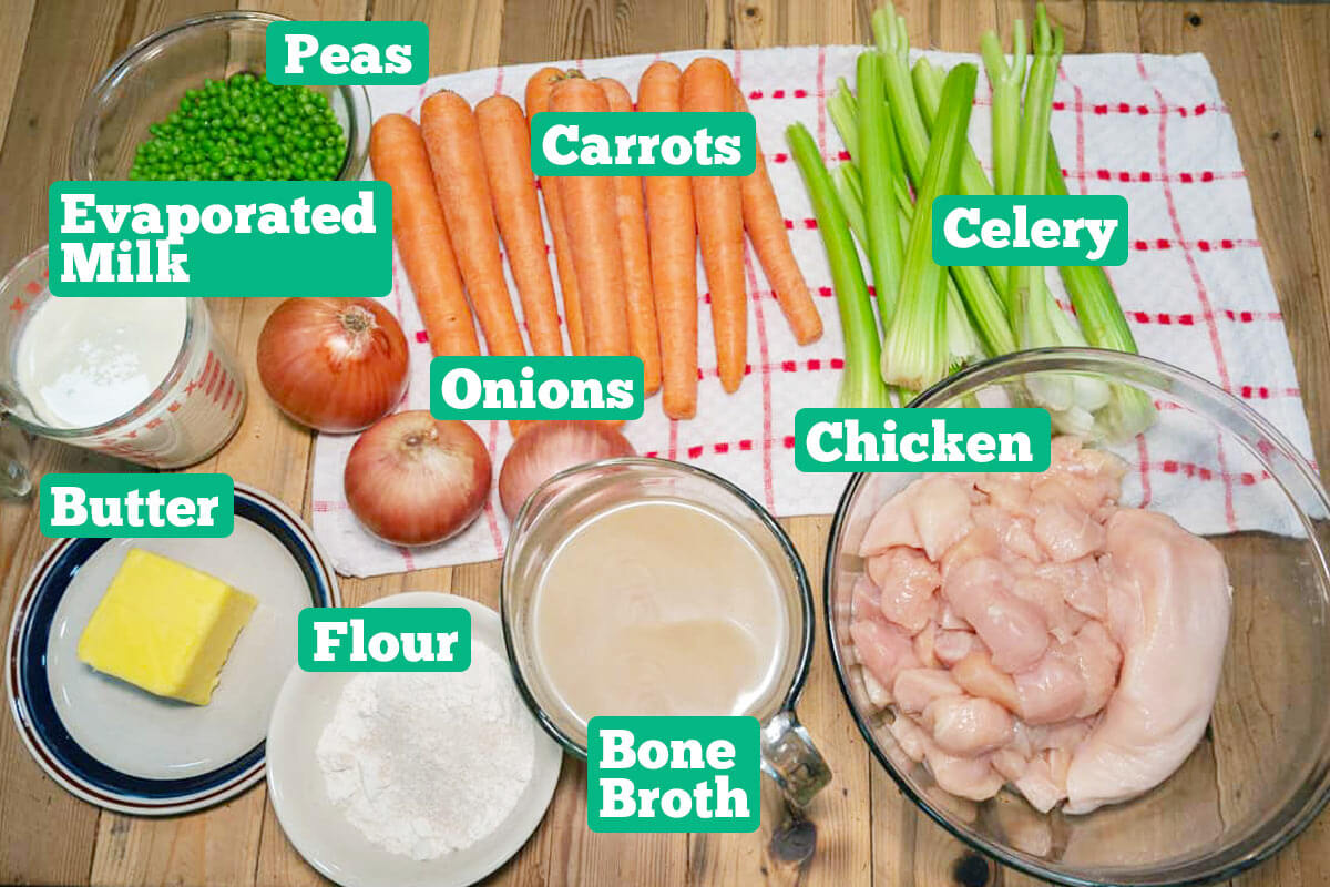 Chicken pot pie ingredients: peas, carrots, celery, chicken, broth, flour, butter, onion, and evaporated milk.