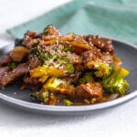 Beef and broccoli stir fry served on a gray plate.