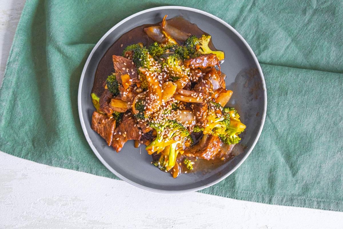 Bird's eye view of beef and broccoli stir fry served on a gray plate.