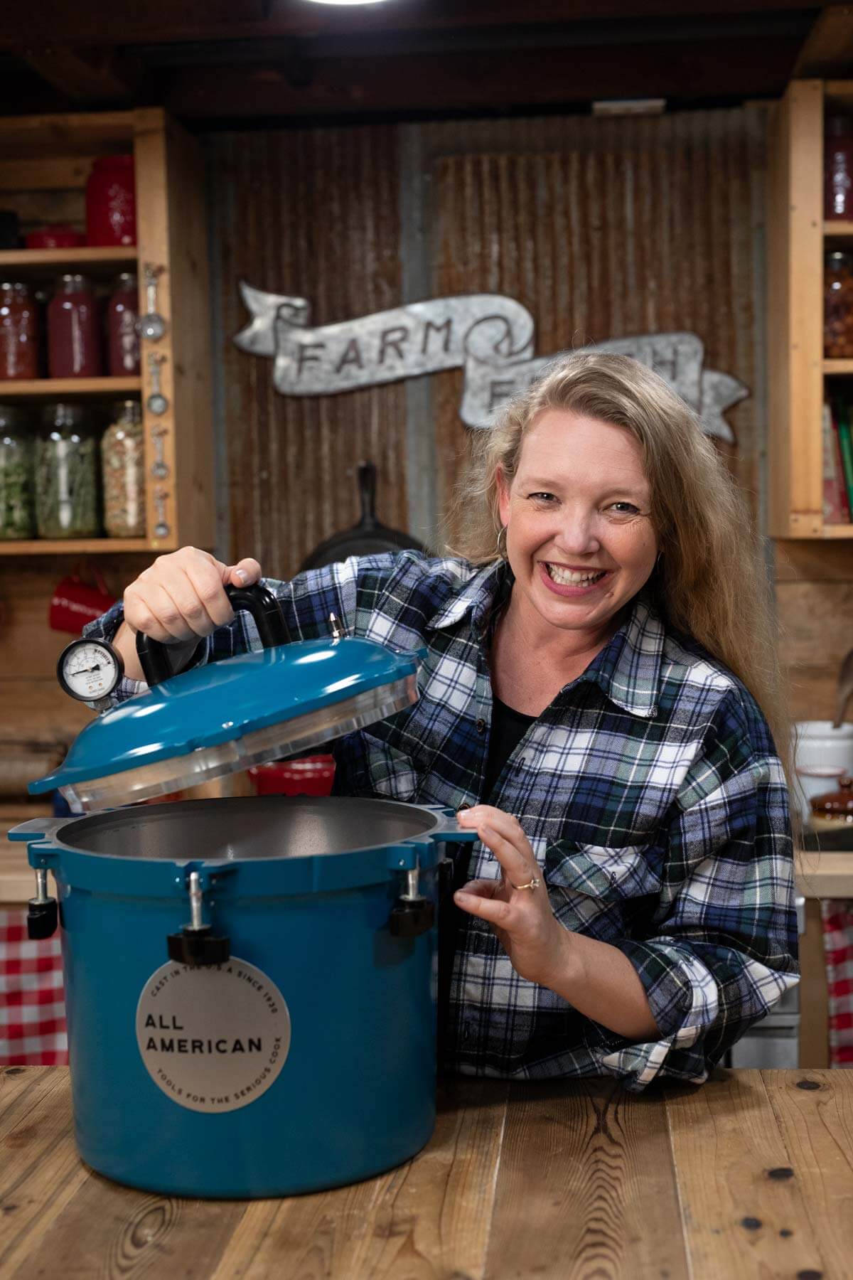 A woman opening a pressure canner.