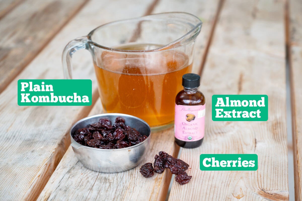 Second ferment kombucha ingredients: plain kombucha, cherries, and almond extract.