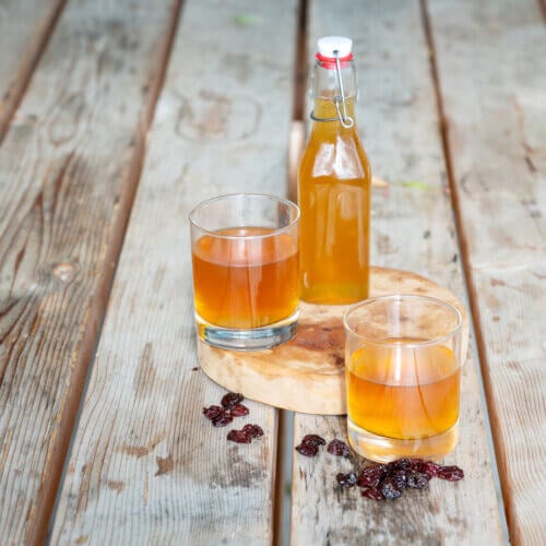 Two glasses and a swing top bottle full of sedond fement kombucha.