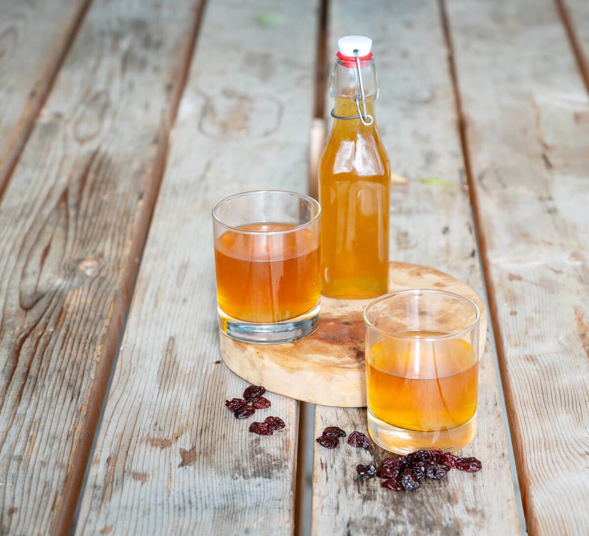 Two glasses and a swing top bottle full of sedond fement kombucha.