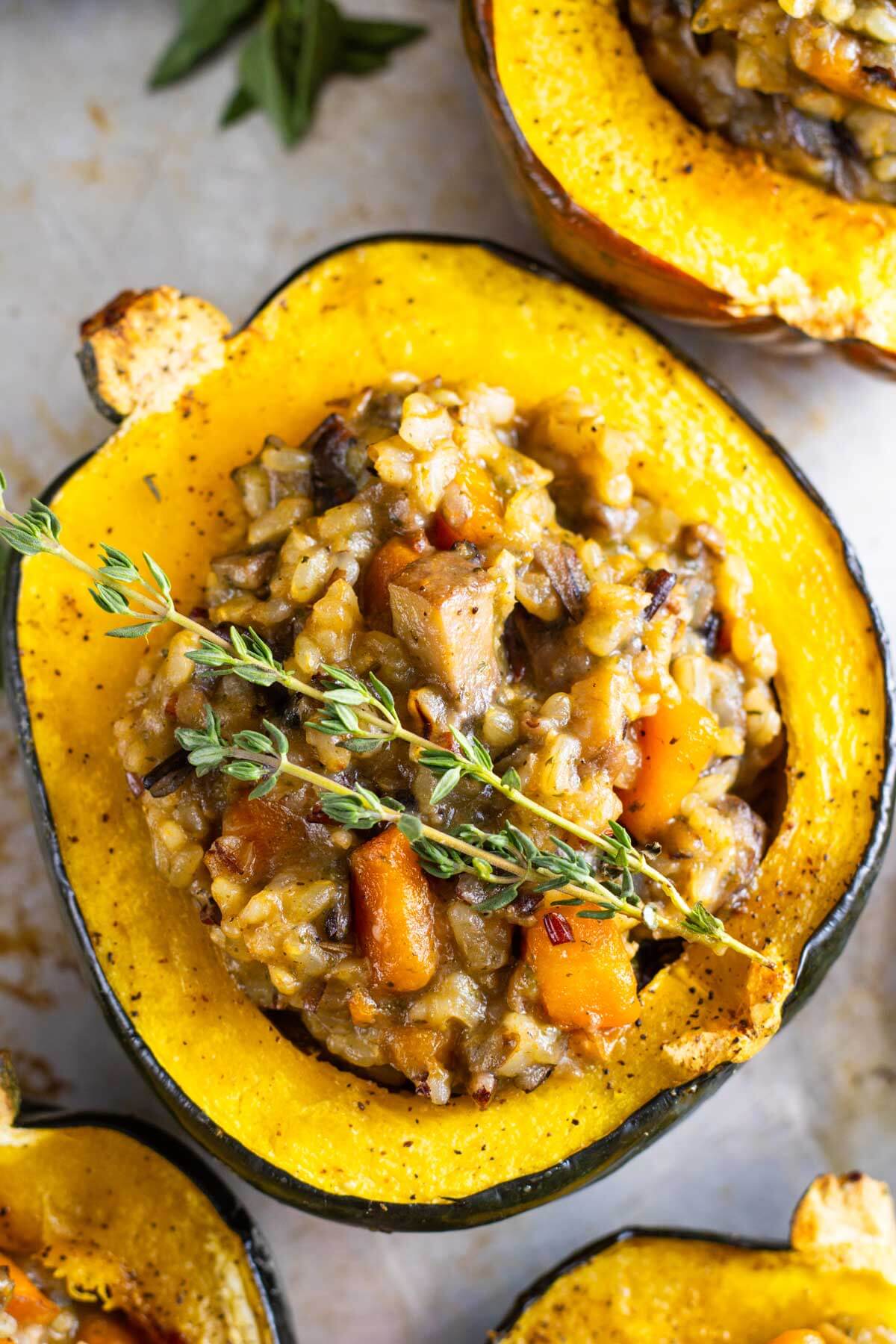 Stuffed acorn squash garnished with fresh herbs.