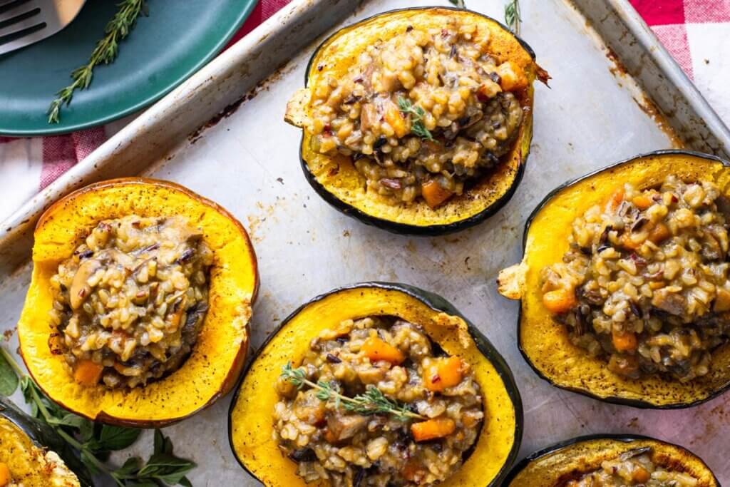 Stuffed acorn squash on a baking sheet fresh from the oven.