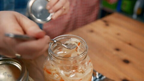 A fork with a bite of homemade Curtido on it.