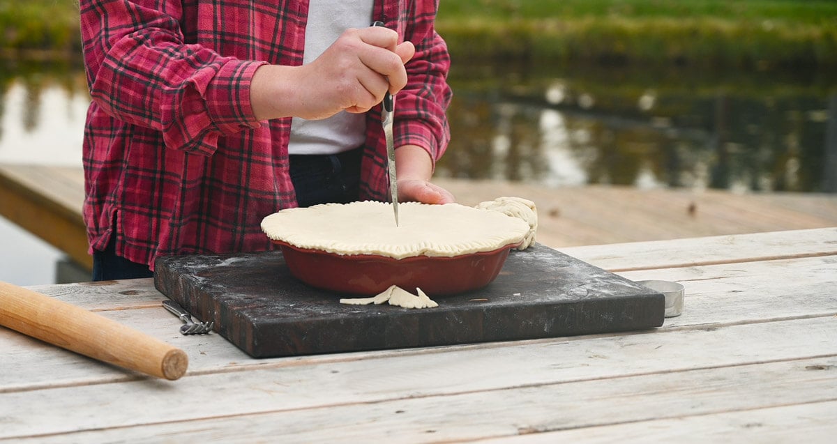 Venting holes being added to the top of an apple pie.