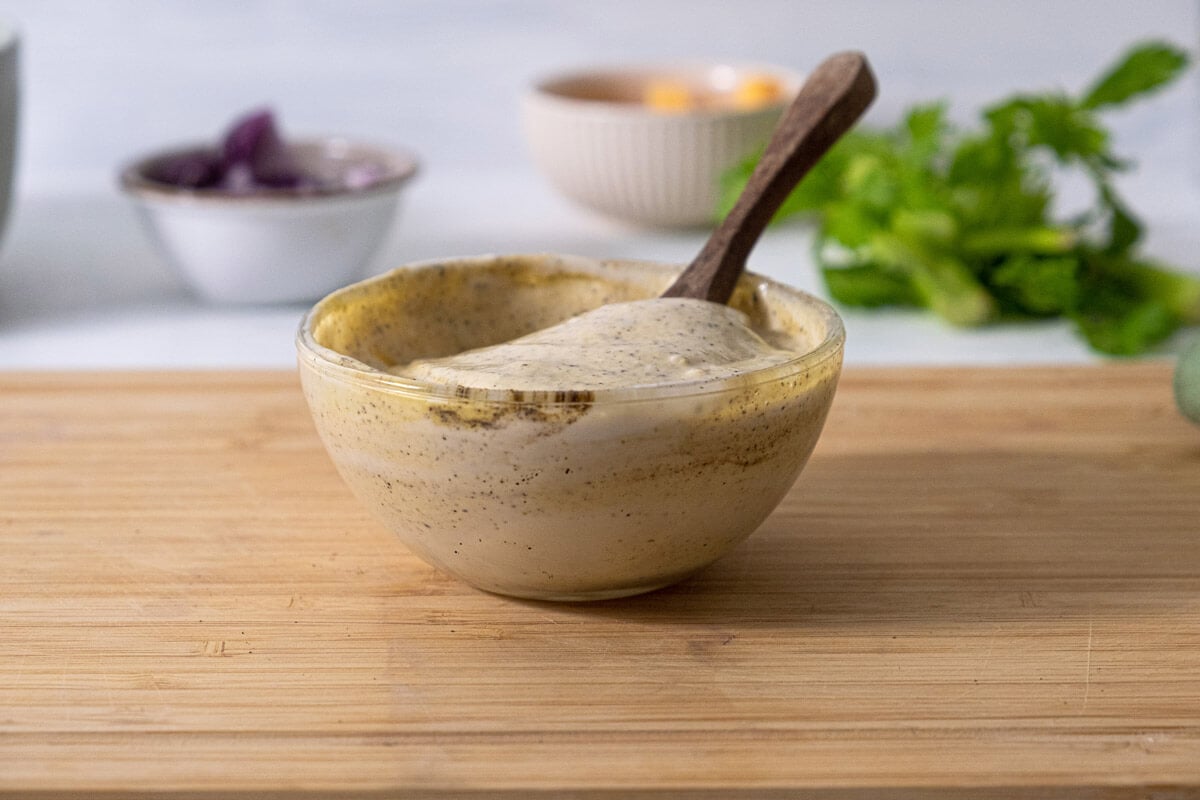 Dressing for green pea salad mixed in a small bowl.