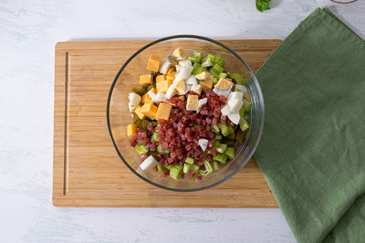 Green pea salad ingredients in a large bowl ready to mix with salad dressing.