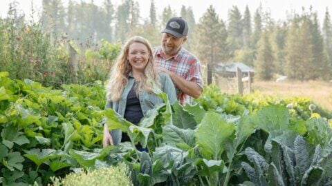 A man and woman standing in a garden.