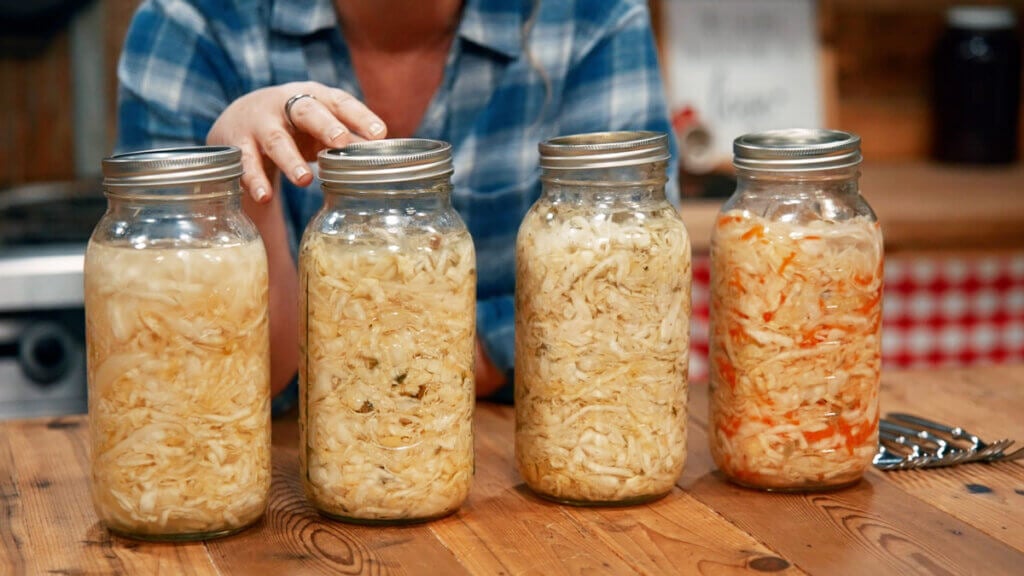 Four different flavors of homemade sauerkraut in jars.