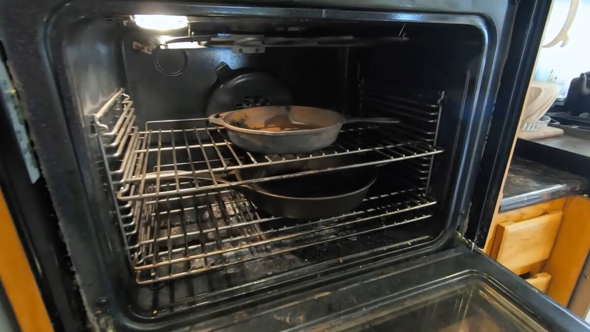 A stripped cast iron pan drying in the oven.